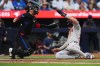 Boston Red Sox's Romy Gonzalez (right) scores as Toronto Blue Jays catcher Danny Jansen (9) looks for the ball during third inning American League MLB baseball action in Toronto on Wednesday, June 19, 2024. THE CANADIAN PRESS/Nathan Denette