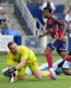 Real Salt Lake forward Andrés Gómez, right, gets past Sporting Kansas City goalkeeper Tim Melia, left, to score a goal during the first half of an MLS soccer match Wednesday, June 19, 2024, in Kansas City, Kan. (AP Photo/Charlie Riedel)