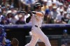 Colorado Rockies' Jake Cave follows the flight of his single to drive in two runs off Los Angeles Dodgers relief pitcher Blake Treinen in the sixth inning of baseball game Thursday, June 20, 2024, in Denver. (AP Photo/David Zalubowski)