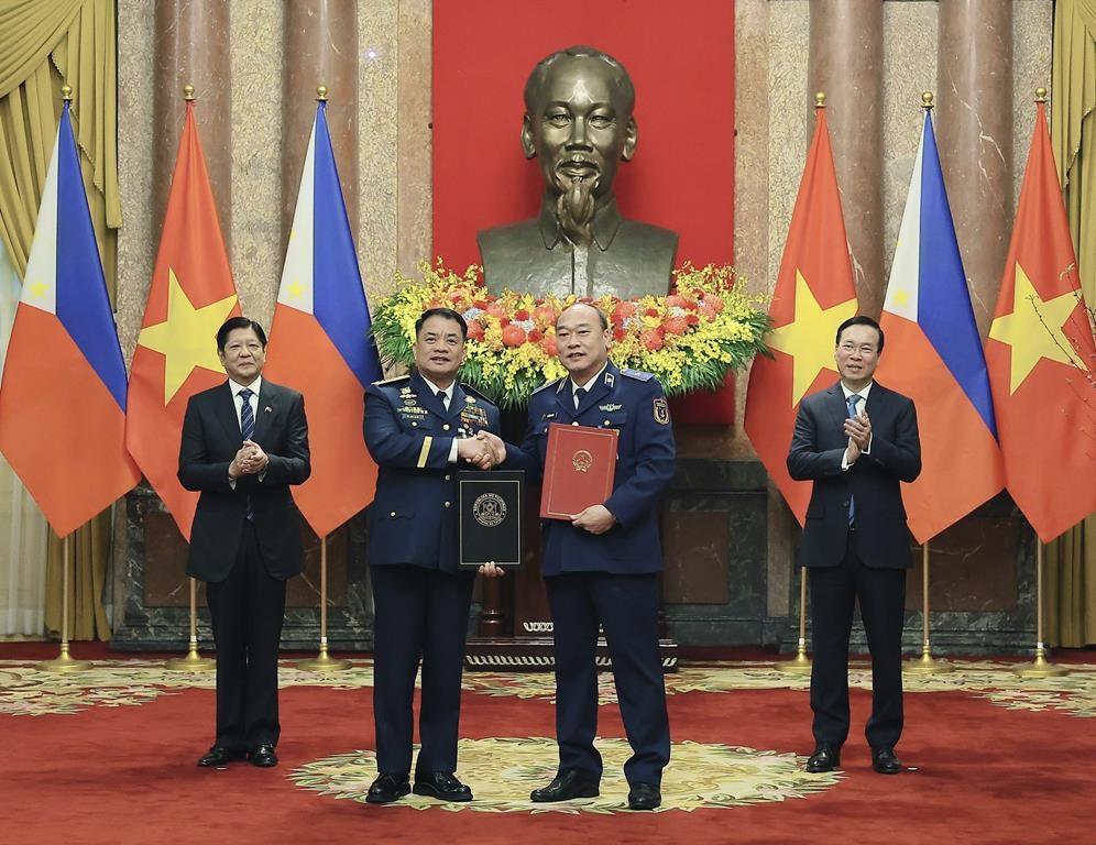 FILE - Philippine President Ferdinand Marcos Jr., left, and Vietnamese President Vo Van Thuong, right, look on as the Philippine Coastguard Commander Adm. Ronnie Gil Gavan and Vietnamese Coastguard Commander Le Quang Dao exchange signed documents in Hanoi, Vietnam Tuesday, Jan. 30, 2024. Vietnam is ready to hold talks with the Philippines to settle their overlapping claims to the undersea continental shelf in the South China Sea, official Vietnamese media said Friday, June 21, 2024, in a diplomatic approach that contrasts with China’s increasingly assertive actions to fortify its claims in the contested waters. (Hoang Thong Nhat/VNA via AP, File)