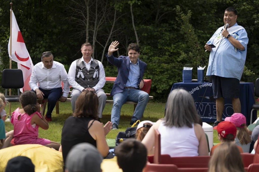 Prime Minister Justin Trudeau acknowledges the crowd while listening to Phillip Prosper, a Mi'kmaq storyteller, during an event for National Indigenous Peoples Day in We’koqma’q First Nation, N.S., on Friday, June 21, 2024. THE CANADIAN PRESS/Darren Calabrese