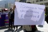 FILE - A merchant holds up a sign with a message that reads in Spanish: 