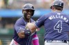 Tampa Bay Rays' Yandy Diaz, left, is greeted by third base coach Brady Williams, right, as he rounds the bases after hitting a home run during the first inning of a baseball game against the Pittsburgh Pirates, Sunday, June 23, 2024, in Pittsburgh. (AP Photo/Matt Freed)