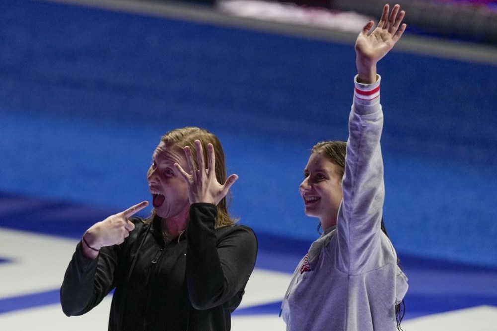 Lilly King shows her engagement ring as Kate Douglass waves after the Women's 200 breaststroke finals Thursday, June 20, 2024, at the US Swimming Olympic Trials in Indianapolis. (AP Photo/Michael Conroy)