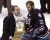 FILE - Anaheim Mighty Ducks goalie Jean-Sebastien Giguere, right, receives the Conn Smythe hockey trophy from NHL Commissioner Gary Bettman, left, after the New Jersey Devils defeated the Ducks to win the Stanley Cup Final, June 9, 2003, in East Rutherford, N.J. Giguere is one of five players to win the Conn Smythe Trophy as playoff MVP despite not winning the Stanley Cup that season. (AP Photo/Rusty Kennedy, File)