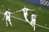 Plastic cups are thrown from the stands at Slovenia's Zan Karnicnik, center, and his teammates celebrating after scoring the opening goal during a Group C match between Slovenia and Serbia at the Euro 2024 soccer tournament in Munich, Germany, Thursday, June 20, 2024. (AP Photo/Ariel Schalit)