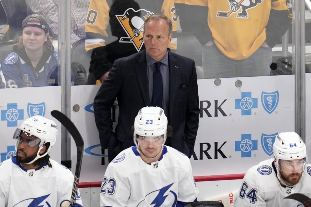 FILE - Tampa Bay Lightning head coach Jon Cooper stands behind his bench during the third period of an NHL hockey game against the Pittsburgh Penguins in Pittsburgh, Saturday, April 6, 2024. Tampa Bay Lightning head coach Jon Cooper will lead Canada at the 2025 4 Nations Face-Off and the 2026 Winter Olympics, Hockey Canada announced Tuesday, June 25. It will be Cooper’s first time as Canada’s head coach since leading the national men’s team to a silver medal at the 2017 world hockey championship. (AP Photo/Gene J. Puskar, File)