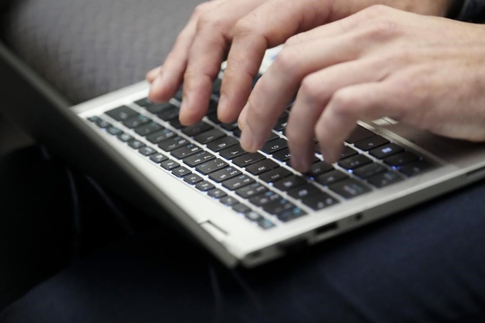 A person types on a laptop computers as President of the Treasury Board Anita Anand speaks during an Artificial Intelligence roundtable attended by AI experts and leaders from across Canada in Gatineau, Que., on Monday, May 27, 2024. THE CANADIAN PRESS/Sean Kilpatrick