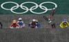 FILE - Felicia Stancil, of the United States, center, looks ahead as the bike of teammate Alise Willoughby flies in the air after she crashed in the BMX Racing semifinals at the 2020 Summer Olympics, Friday, July 30, 2021, in Tokyo, Japan. BMX racing has been described as NASCAR on two wheels, only stock car racing is probably a whole lot safer.(AP Photo/Ben Curtis, File)