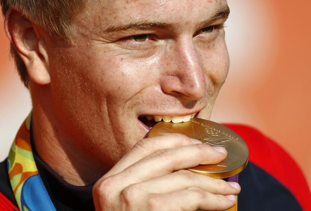 FILE - Connor Fields, of the United States, bites his gold medal during a victory ceremony for the men's BMX cycling final during the 2016 Olympic Games in Rio de Janeiro, Brazil, Friday, Aug. 19, 2016. “There's no way to check this,