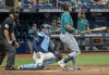 umpire Brian Knight (91) and Tampa Bay Rays catcher Alex Jackson, center look on as Seattle Mariners' Cal Raleigh hits a three-run home run to right field during the sixth inning of a baseball game Wednesday, June 26, 2024, in St. Petersburg, Fla. (AP Photo/Steve Nesius)