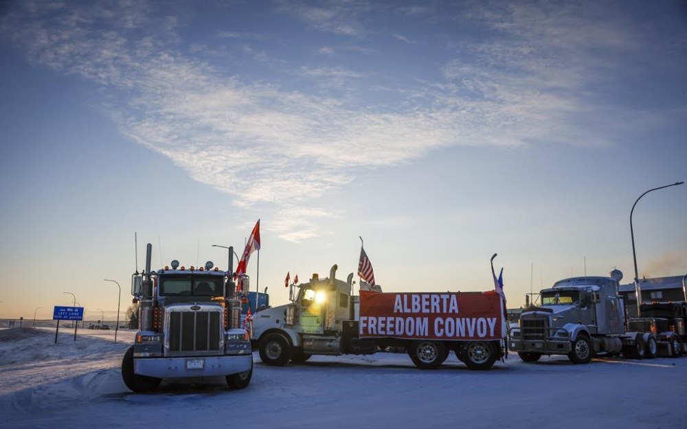 A truck convoy of anti-COVID-19 vaccine mandate demonstrators block the highway at the busy U.S. border crossing in Coutts, Alta., Wednesday, Feb. 2, 2022. A police phone expert is to continue testifying today at the trial for two men charged with conspiracy to commit murder at the border blockade at Coutts, Alta. THE CANADIAN PRESS/Jeff McIntosh
