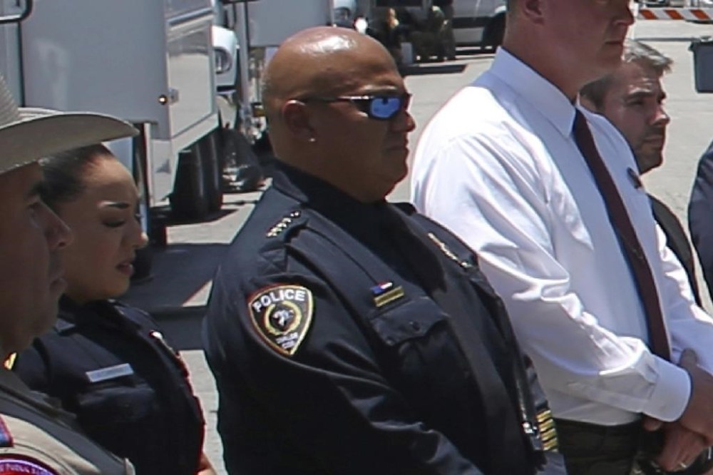 FILE - Uvalde School Police Chief Pete Arredondo, third from left, stands during a news conference outside of the Robb Elementary school on May 26, 2022, in Uvalde, Texas. Arredondo was arrested and briefly booked into the Uvalde County jail before he was released Thursday, June 27, 2024, on 10 state jail felony counts of abandoning or endangering a child in the May 24, 2022, attack that killed 19 children and two teachers. (AP Photo/Dario Lopez-Mills, File)