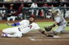 Arizona Diamondbacks' Ketel Marte, left, scores ahead of a tag by Oakland Athletics catcher Shea Langeliers, right, during the first inning of a baseball game Friday, June 28, 2024, in Phoenix. (AP Photo/Ross D. Franklin)
