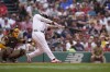 Boston Red Sox's Rafael Devers, right, hits a two-run home run off a pitch by San Diego Padres' Matt Waldron as Padres catcher Kyle Higashioka, left, looks on in the first inning of a baseball game, Sunday, June 30, 2024, in Boston. (AP Photo/Steven Senne)