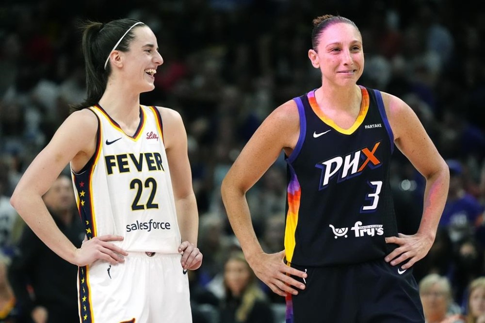 Indiana Fever guard Caitlin Clark (22) and Phoenix Mercury guard Diana Taurasi (3) laugh during the first half of a WNBA basketball game Sunday, June 30, 2024, in Phoenix. (AP Photo/Ross D. Franklin)