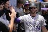Colorado Rockies' Ryan McMahon celebrates with teammates after scoring on a balk by Chicago White Sox starting pitcher Garrett Crochet during the second inning of a baseball game in Chicago, Sunday, June 30, 2024. (AP Photo/Nam Y. Huh)