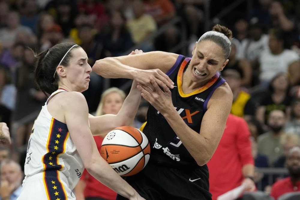 Phoenix Mercury guard Diana Taurasi, right, is fouled by Indiana Fever guard Caitlin Clark, left, during the second half of a WNBA basketball game Sunday, June 30, 2024, in Phoenix. (AP Photo/Ross D. Franklin)