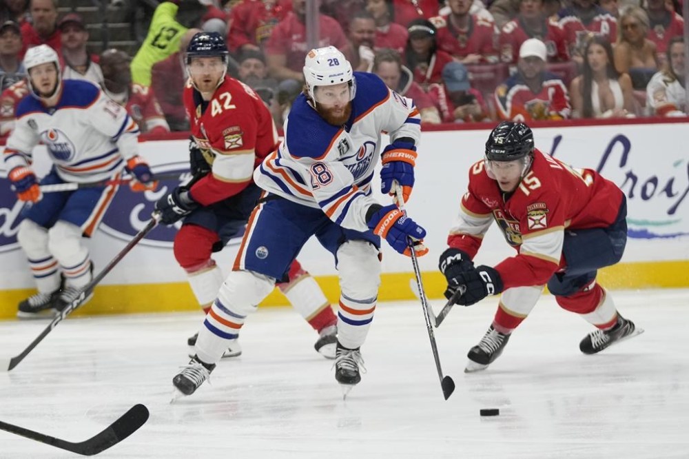 Edmonton Oilers right wing Connor Brown (28) controls the puck as Florida Panthers centre Anton Lundell (15) defends during the first period of Game 5 of the NHL hockey Stanley Cup Finals, Tuesday, June 18, 2024, in Sunrise, Fla. The Oilers have re-signed forward Brown to a one-year contract worth US$1 million.THE CANADIAN PRESS/AP/Wilfredo Lee