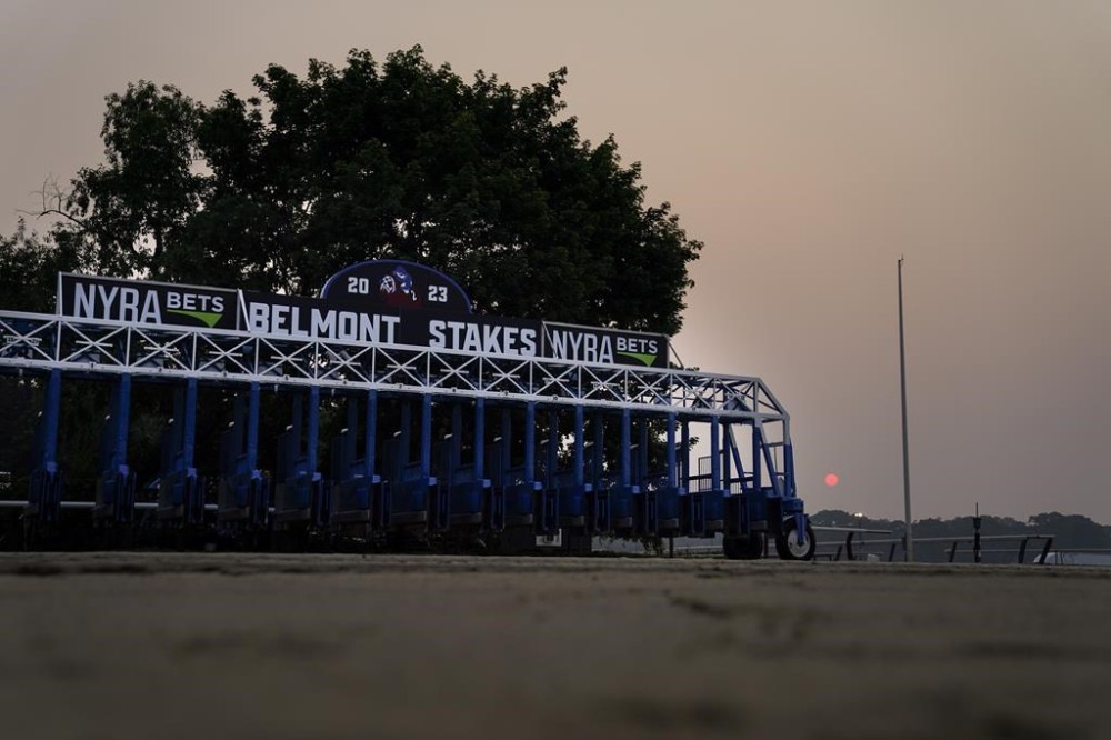 FILE -A starting gate rests unused on an empty track as haze from Canadian wildfires obscures the sun ahead of the Belmont Stakes horse race, Thursday, June 8, 2023, at Belmont Park in Elmont, N.Y. Winter racing at Belmont Park when the track reopens in 2026 will be exclusively run on synthetic tracks. The New York Racing Association announced that move Monday, July 1, 2024. (AP Photo/John Minchillo, File)