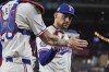Texas Rangers starting pitcher Nathan Eovaldi, right, gets a congratulatory hand from teammate catcher Jonah Heim (28) after the third out during the seventh inning of a baseball game against the San Diego Padres in Arlington, Texas, Tuesday, July 2, 2024. (AP Photo/LM Otero)