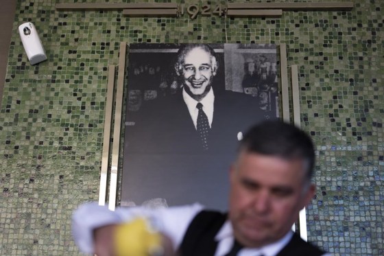 Salad Master Efrain Montoya prepares a Caesar salad in front of an image of the inventor of the salad, Caesar Cardini, at Ceasar's restaurant in Tijuana, Mexico. (Gregory Bull / The Associated Press files)