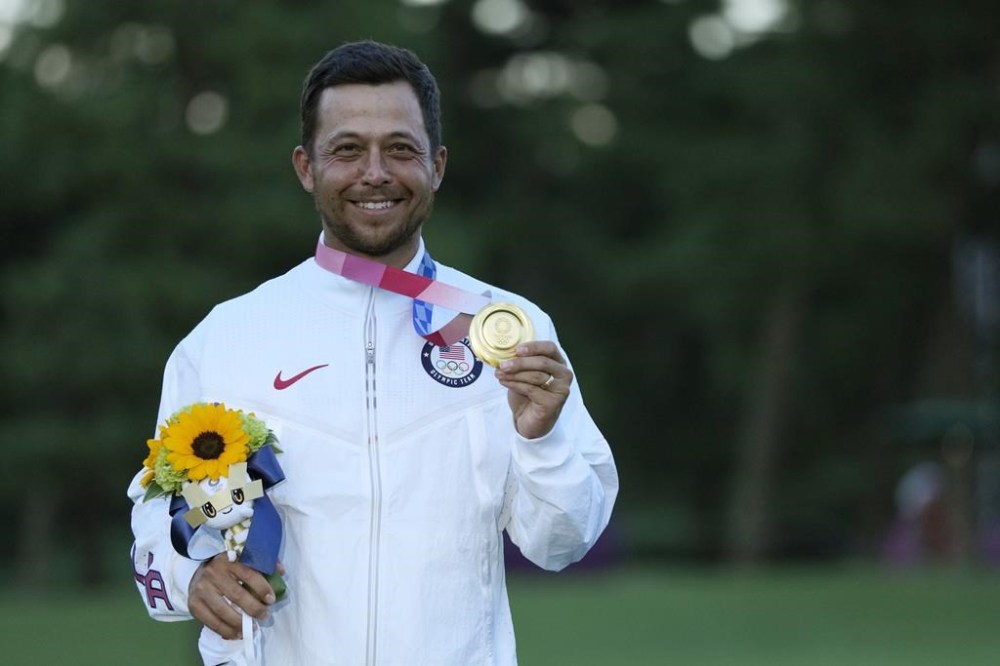 FILE - Xander Schauffele, of the United States, holds his gold medal in the men's golf at the 2020 Summer Olympics on Sunday, Aug. 1, 2021, in Kawagoe, Japan. Qualifying for the Paris Games was the hardest part for Schauffele and the Americans. ((AP Photo/Andy Wong, File)