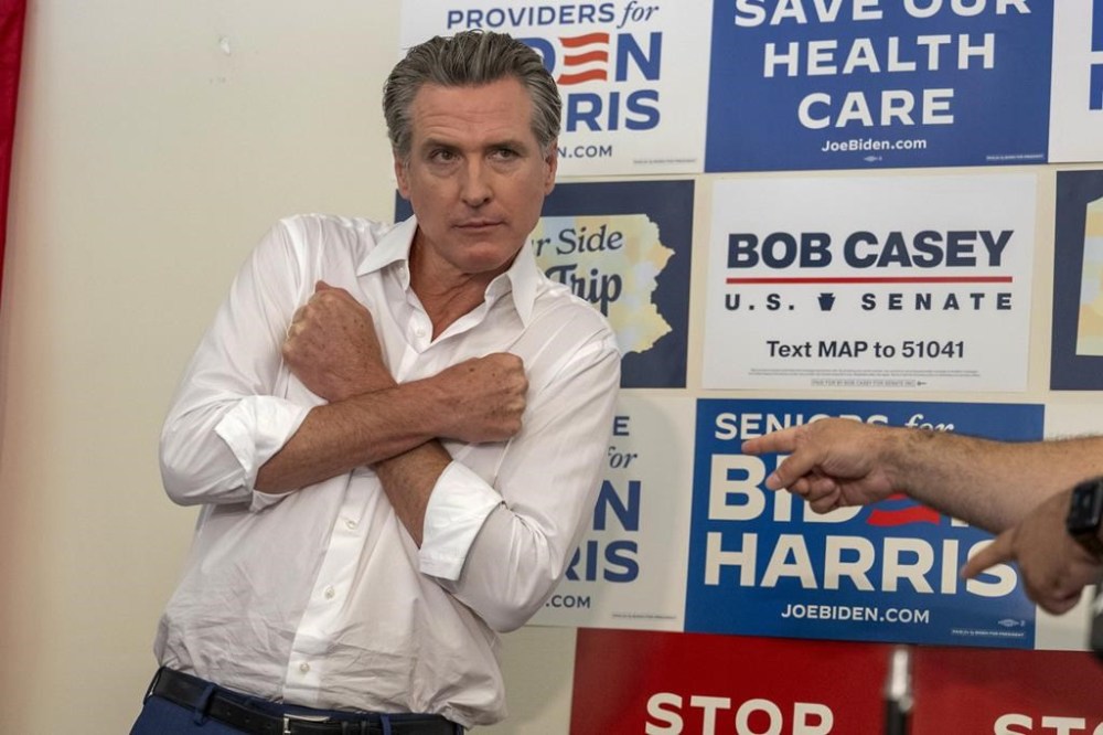 California Gov. Gavin Newsom poses as State Representative Nick Pisciottano points to him during a campaign stop supporting President Joe Biden on Friday, July 5, 2024, outside Pittsburgh. The stop was held at a Biden Harris campaign head quarters. (Benjamin B. Braun/Pittsburgh Post-Gazette via AP)