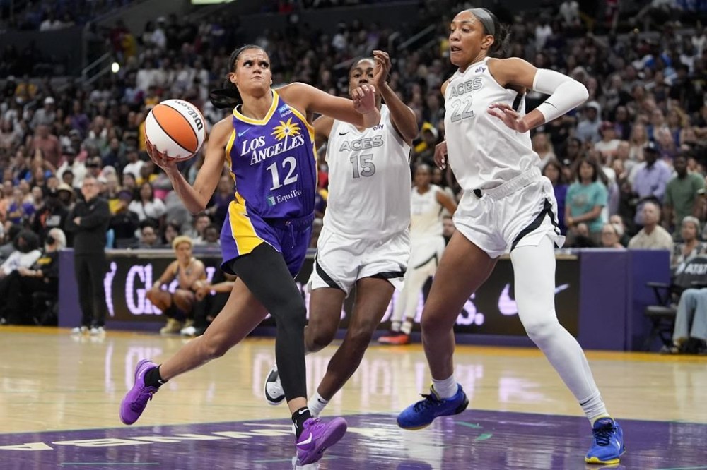 Los Angeles Sparks guard Rae Burrell, left, drives against Las Vegas Aces guard Tiffany Hayes, center, and center A'ja Wilson during the first half of a WNBA basketball game, Friday, July 5, 2024, in Los Angeles. (AP Photo/Ryan Sun)