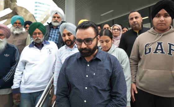 Sarbjit Gill's husband, Sukhwinder Gill (centre), along with their children Eknoor (GAP hoodie) and Balnoor (light grey hoodie), family and friends, leave the Law Courts building after sentencing Tuesday. (Ruth Bonneville / Free Press)