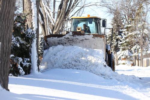 RUTH BONNEVILLE / FREE PRESS FILES
                                A snow plow clears back lanes in the area around Churchill Drive. The city is a blaming a budget deficit, in part, on high snow-clearing and ice control costs.