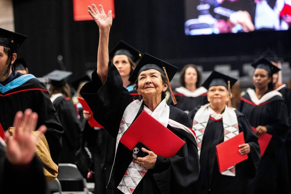 MIKAELA MACKENZIE / FREE PRESS
                                U of W’s Developmental Studies program graduate Victoria Antsanen waves while leaving the graduation ceremony on Friday.