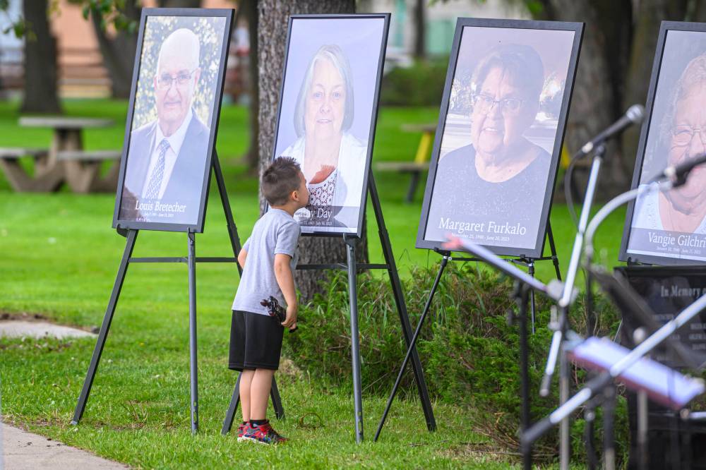 Sage Patterson kisses a photo of his grandmother, Catherine Day, at a ceremony in Dauphin on Saturday commemorating the victims of a deadly bus crash near Carberry last year. (Mike Sudoma / The Canadian Press)