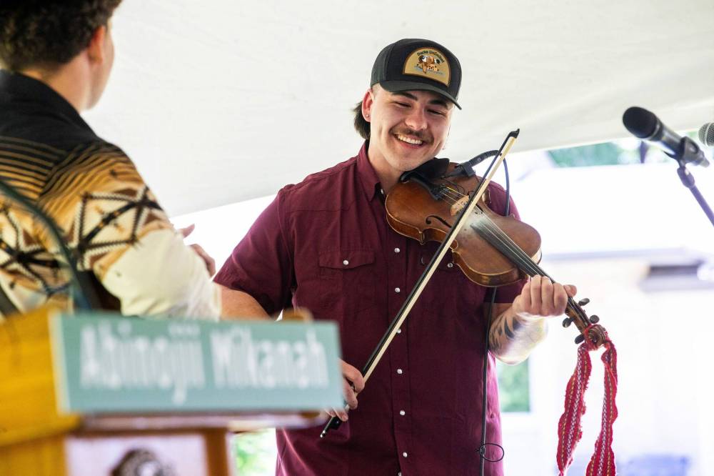 Luc Wrigley plays the Orange Blossom Special at the Abinojii Mikanah renaming ceremony. (Mikaela MacKenzie / Free Press)