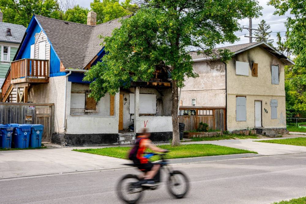 NIC ADAM / FREE PRESS
Four burned houses in the William Whyte community sit in a row, vacant, along Powers Ave Friday.