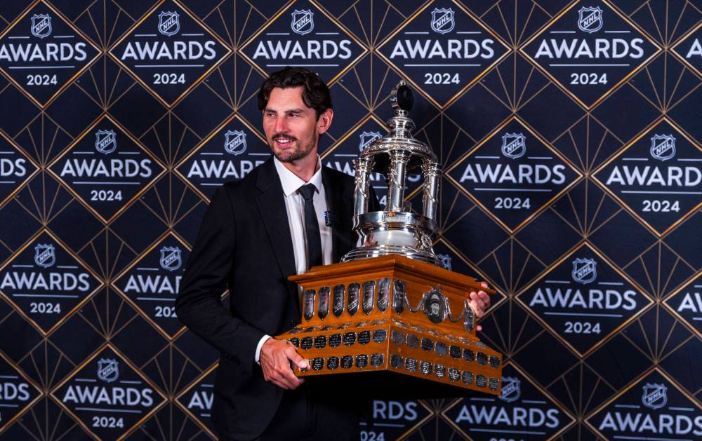 Winnipeg Jets goaltender Connor Hellebuyck holds the Vezina Trophy at the NHL Awards, Thursday in Las Vegas. (AP Photo/L.E. Baskow)