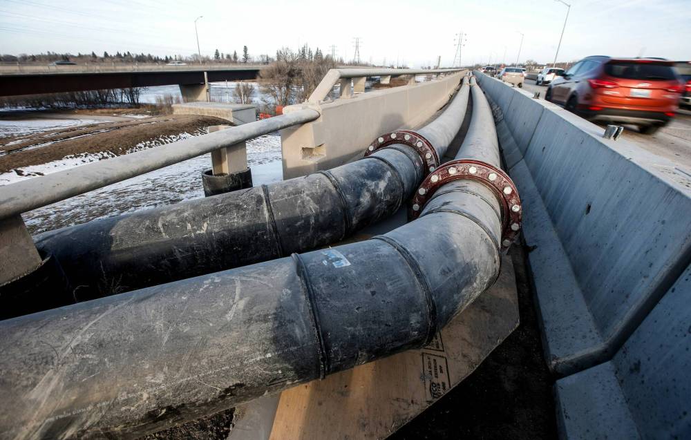 JOHN WOODS / FREE PRESS FILES
City crews work to bypass a sewage leak across the Red River at the Fort Garry Bridge in Winnipeg in February.