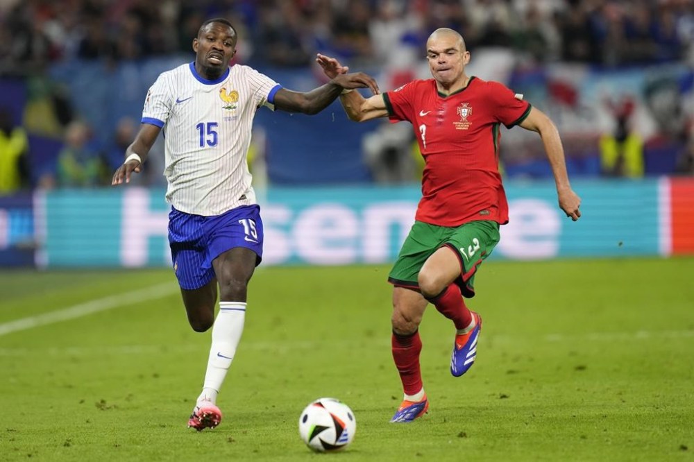 Marcus Thuram of France, left, and Portugal's Pepe vie for the ball during a quarter final match at the Euro 2024 soccer tournament in Hamburg, Germany, Friday, July 5, 2024. (AP Photo/Hassan Ammar)