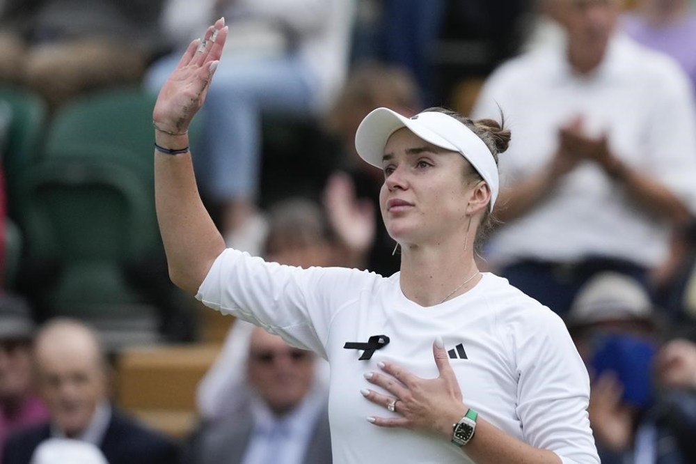Elina Svitolina of Ukraine waves after defeating Xinyu Wang of China in their fourth round match at the Wimbledon tennis championships in London, Monday, July 8, 2024. (AP Photo/Mosa'ab Elshamy)