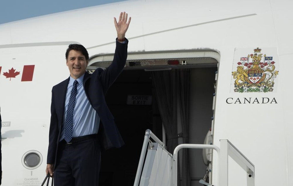 Prime Minister Justin Trudeau waves as he boards a government plane as he departs for the NATO Summit from the airport on July 8, 2024 in Ottawa. THE CANADIAN PRESS/Adrian Wyld