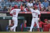 Los Angeles Angels' Mickey Moniak, left, celebrates with Anthony Rendon, right, after scoring off a single hit by Jo Adell during the second inning of a baseball game against the Texas Rangers, Monday, July 8, 2024, in Anaheim, Calif. (AP Photo/Ryan Sun)