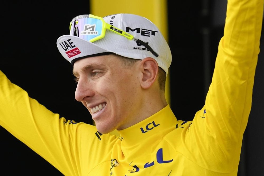 Slovenia's Tadej Pogacar, wearing the overall leader's yellow jersey, celebrates on the podium after the tenth stage of the Tour de France cycling race over 187.3 kilometers (116.4 miles) with start in Orleans and finish in Saint-Amand-Montrond, France, Tuesday, July 9, 2024. (AP Photo/Jerome Delay)
