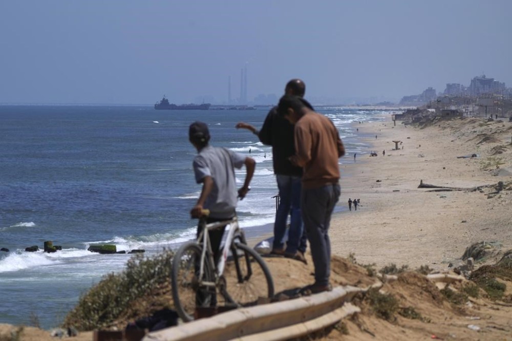 FILE - A ship is seen off the coast of Gaza near a U.S.-built floating pier that will be used to facilitate aid deliveries, as seen from the central Gaza Strip, Thursday, May 16, 2024. The pier built by the U.S. military to bring humanitarian aid to Gaza will be reinstalled Wednesday, July 10, 2024, to be used for several days, but then the plan is to pull it out permanently, several U.S. officials said. (AP Photo/Abdel Kareem Hana, File)