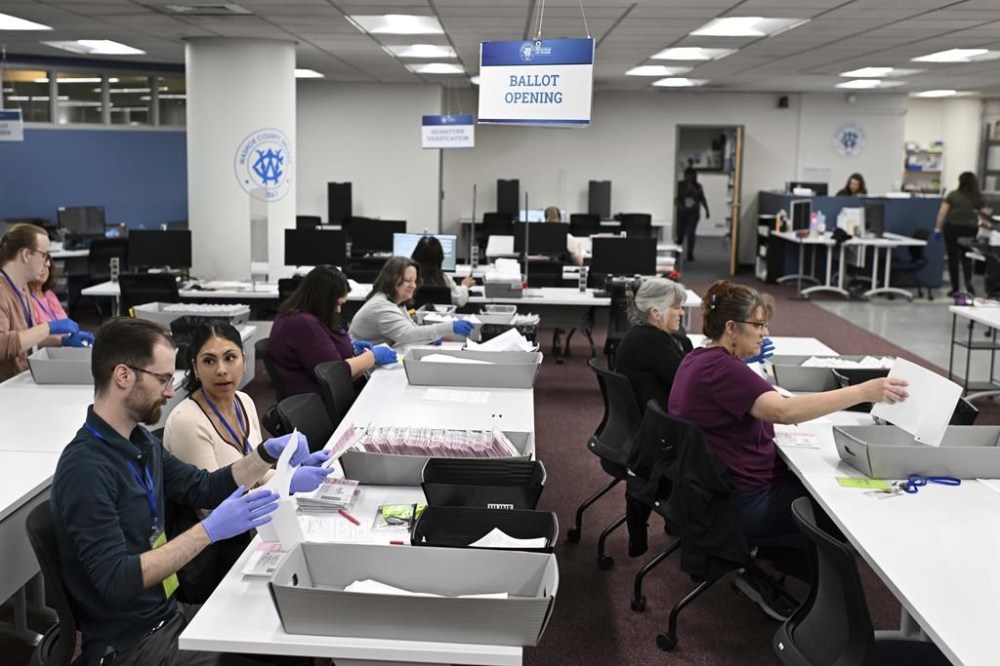 FILE - County employees open ballots in the ballot opening area of the mail ballot processing room at the Washoe County Registrar of Voters office in Reno, Nev. on Monday June 3, 2024 .Commissioners in Nevada’s second most populous county, Tuesday, July 9, 2024, refused to certify the results of two local recounts from last month’s primary, a rare move that has potential implications for the presidential race in one of the nation’s most important swing states. (AP Photo/Andy Barron, File)