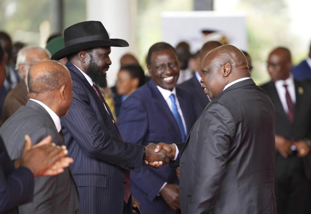 FILE - South Sudanese President Salva Kiir Mayardit, left, shakes hands with Pagan Amum Okiech, leader of the Real-SPLM group, during the launch of high-level peace talks for South Sudan at State House in Nairobi, Kenya, on Thursday, May 9, 2024. South Sudan peace talks that almost reached completion faced a stumbling block with opposition groups demanding a newly passed bill allowing the detention of people without an arrest warrant scratched out in order to sign a proposed agreement. (AP Photo/Brian Inganga, File)
