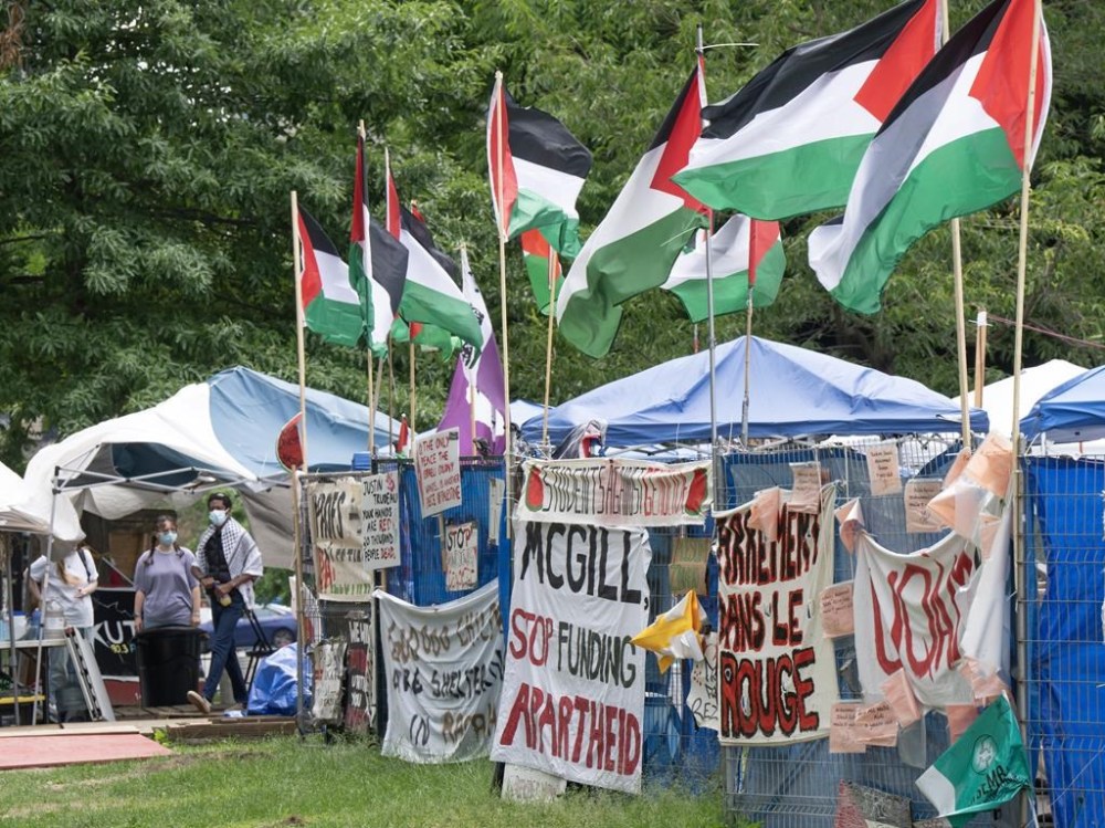 Supporters stand in front of the pro-Palestinian protest encampment on McGill University campus, in Montreal, Monday, June 17, 2024. THE CANADIAN PRESS/Ryan Remiorz