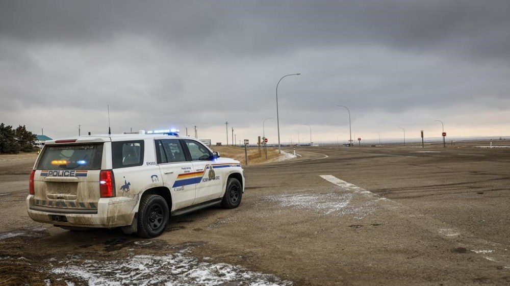 A defence lawyer for one of two men accused of conspiracy to commit murder at the border blockade at Coutts, Alta., has suggested many of the guns seized by police are rifles used for hunting small game. A police vehicle is parked after the blockade of the highway ended at the busy Canada-U.S. border crossing in Coutts, Alta., Tuesday, Feb. 15, 2022.THE CANADIAN PRESS/Jeff McIntosh