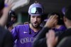 Colorado Rockies' Sam Hilliard, center, celebrates with teammates in the dugout after hitting a two-run home run during the third inning of a baseball game against the Cincinnati Reds, Wednesday, July 10, 2024, in Cincinnati. (AP Photo/Jeff Dean)
