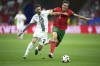 Portugal's Joao Palhinha, right, challenges for the ball with Slovenia's Petar Stojanovic during a round of sixteen match between Portugal and Slovenia at the Euro 2024 soccer tournament in Frankfurt, Germany, Monday, July 1, 2024. (AP Photo/Ebrahim Noroozi)