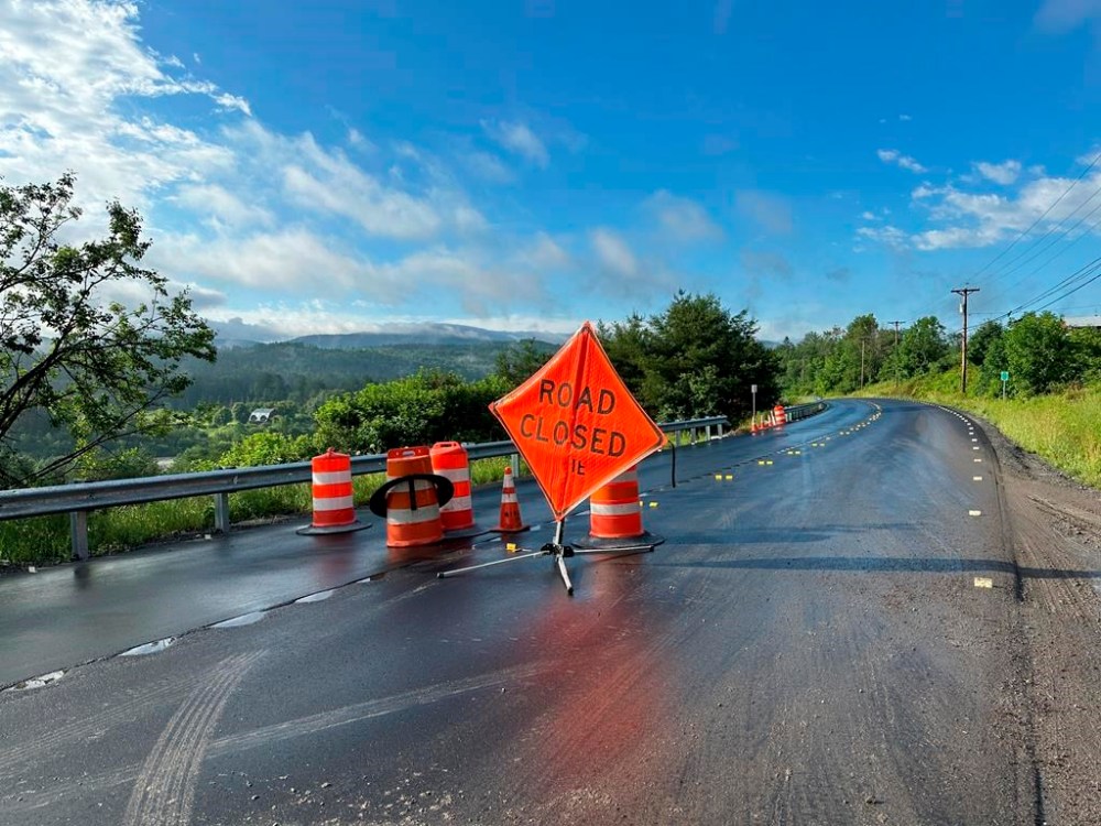 A sign warns of a road closed by flooding in Marshfield, Vt., Thursday, July 11, 2024. (AP Photo/Lisa Rathke)